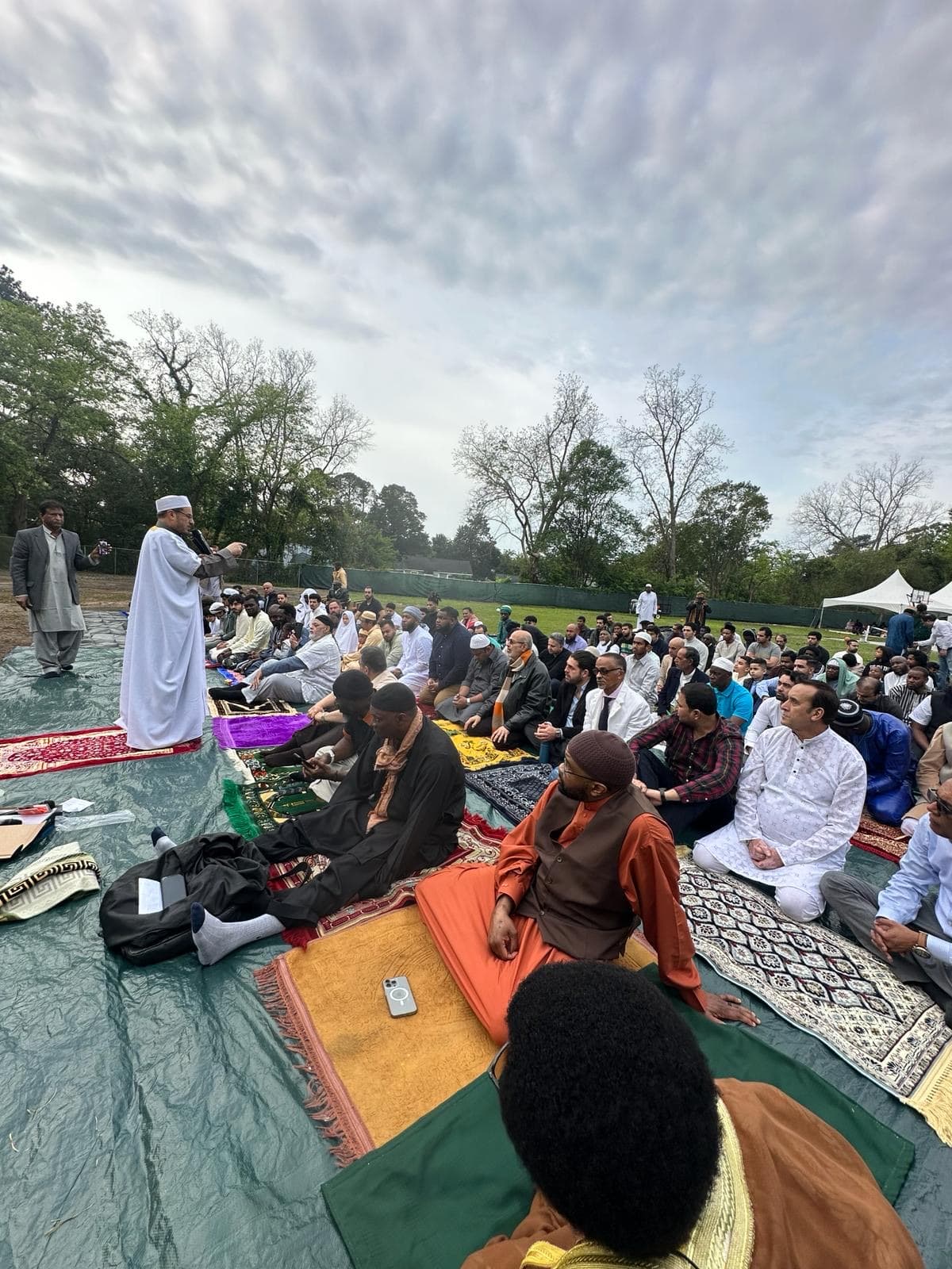 The congregation seated on mats across the field for the Eid prayer